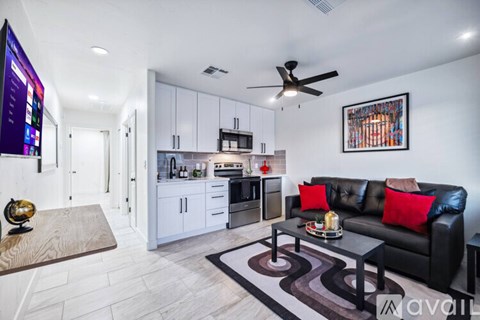 A modern living room with a black couch and a flat screen TV.