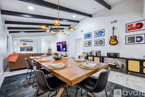 A modern dining room with a wooden table set for a meal.