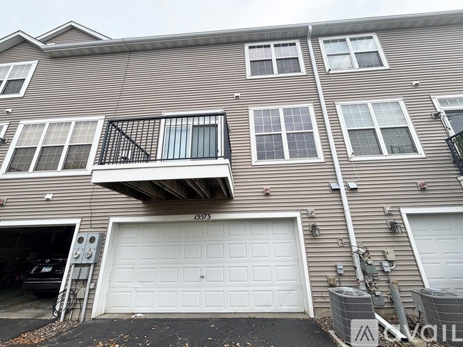 A two-story apartment building with a balcony on the second floor.