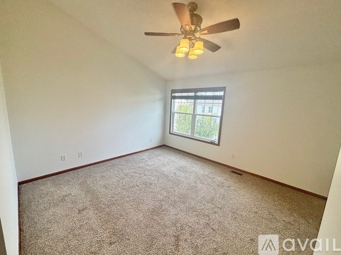 A room with a ceiling fan and a window.