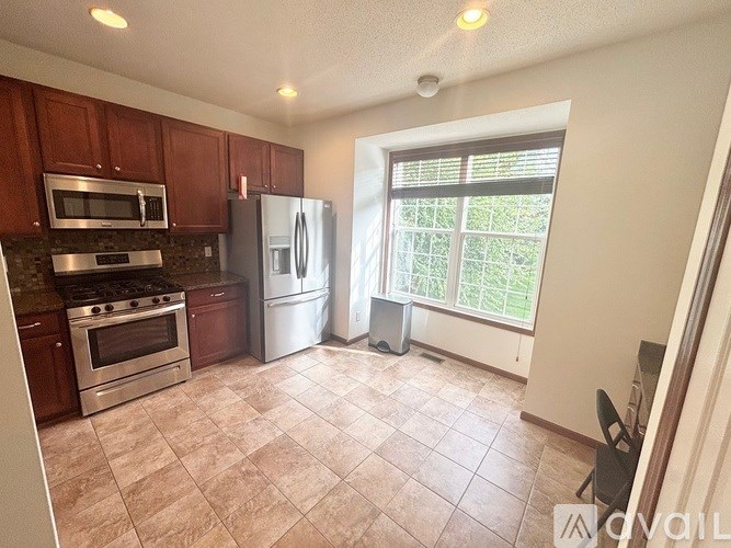 A kitchen with brown cabinets and a white refrigerator.