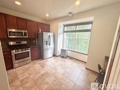 A kitchen with brown cabinets and a white refrigerator.