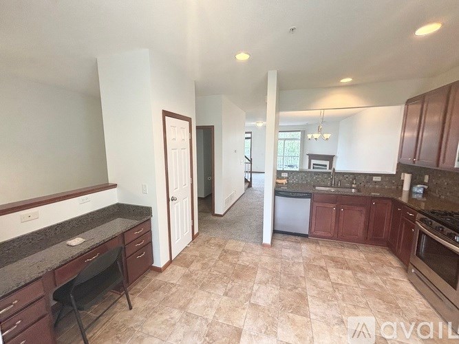 A kitchen with brown cabinets and a black chair.