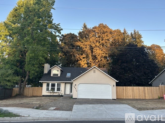 A house with a garage and a driveway in front of it.
