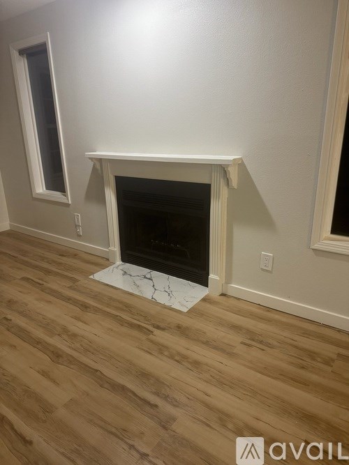 A room with a fireplace and wooden flooring.