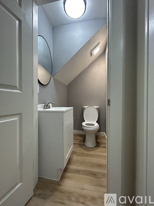 A small white toilet sits in a narrow bathroom.