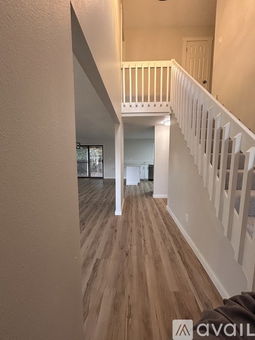 A house with a wooden fence in front of it is for sale.