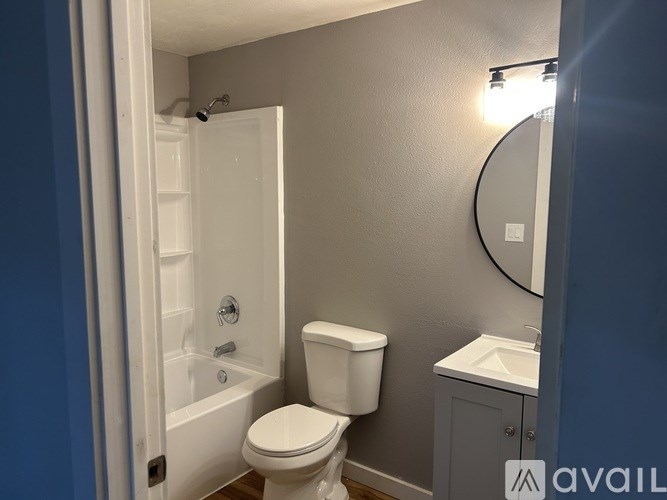 A bathroom with a toilet, sink, and bathtub.