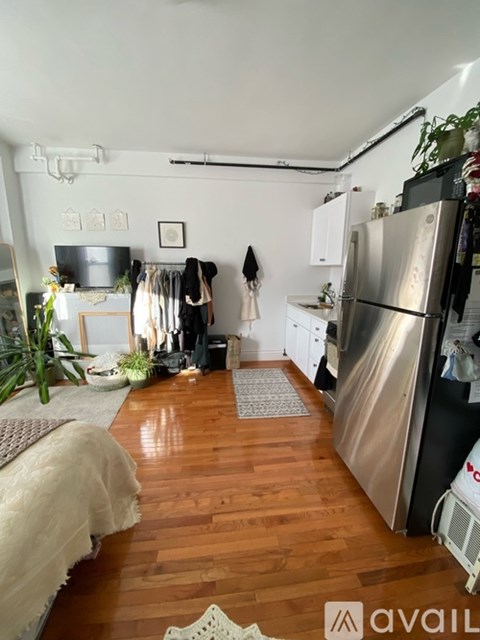 A kitchen with a refrigerator, a sink, and a dining table.