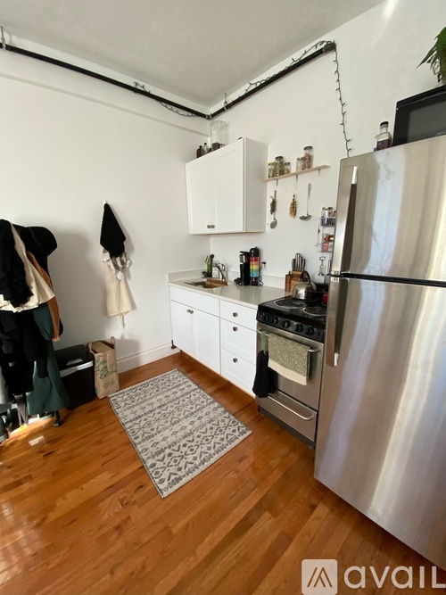 A kitchen with a refrigerator, oven, and sink.