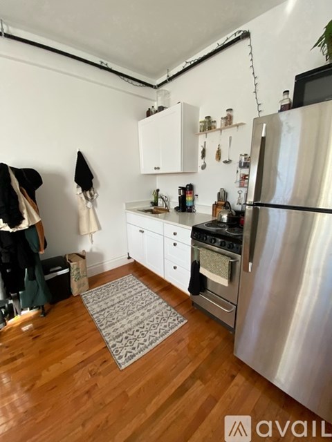 A kitchen with a refrigerator, oven, and sink.