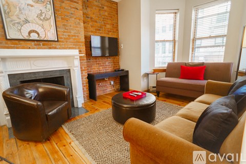 A living room with a fireplace and a brown couch.