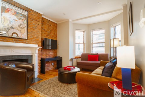 A living room with a fireplace and a painting on the wall.