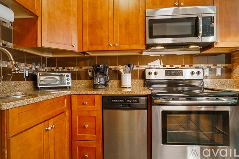 A kitchen with wooden cabinets and a stainless steel oven.