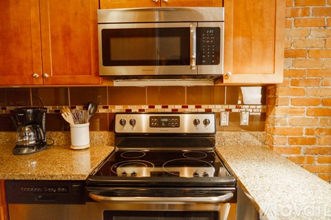A kitchen with a stove, microwave, and oven.
