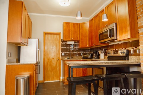 A kitchen with wooden cabinets and a brick wall.