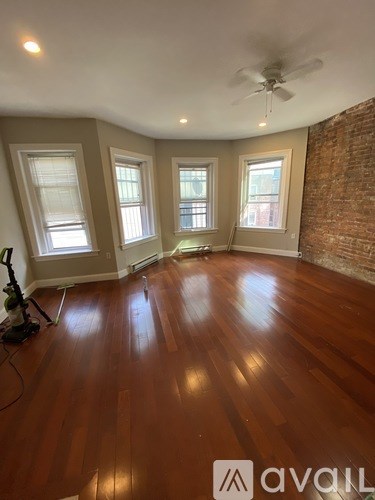 A room with wooden floors and a ceiling fan.