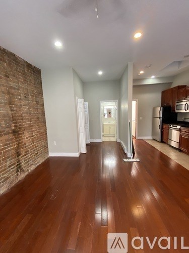 A room with wooden floors and a brick wall.