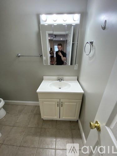 A bathroom with a white sink and a mirror.