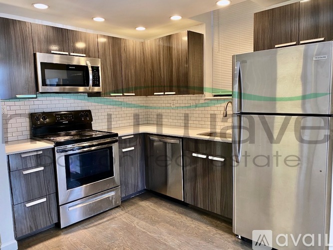 A kitchen with a stainless steel refrigerator, microwave, oven, and cabinets.
