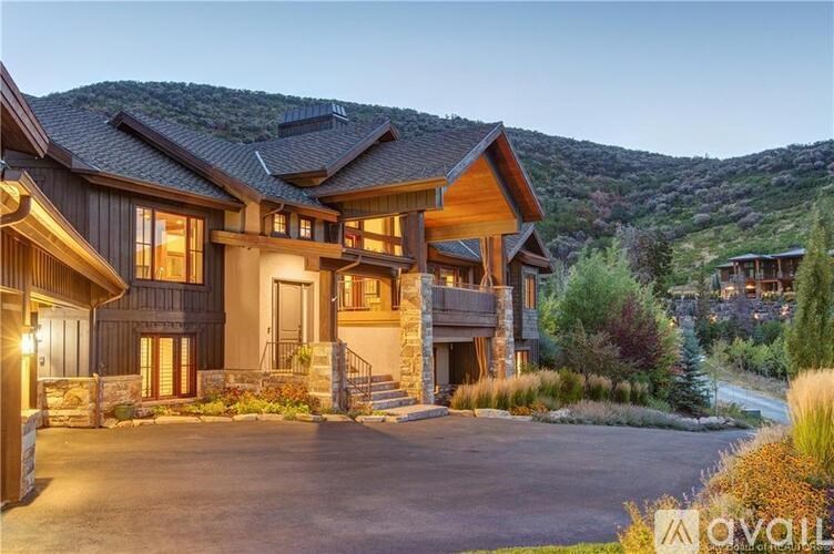 A large house with a mountain in the background is available for sale.