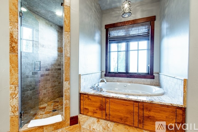 A bathroom with a glass shower door and a window.