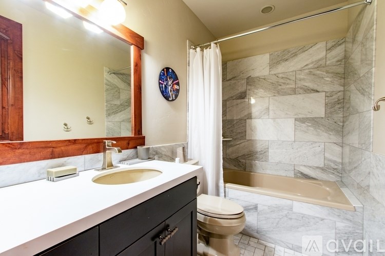 A bathroom with a marble tile shower and a toilet.