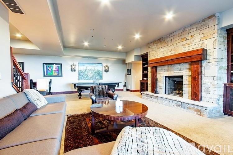A living room with a stone fireplace and a couch.