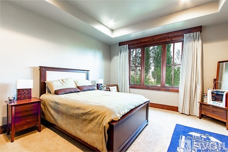 A bedroom with a bed, nightstand, and window.