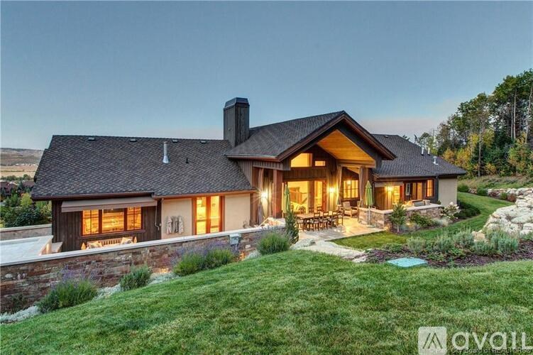 A house with a stone wall and a large front yard.
