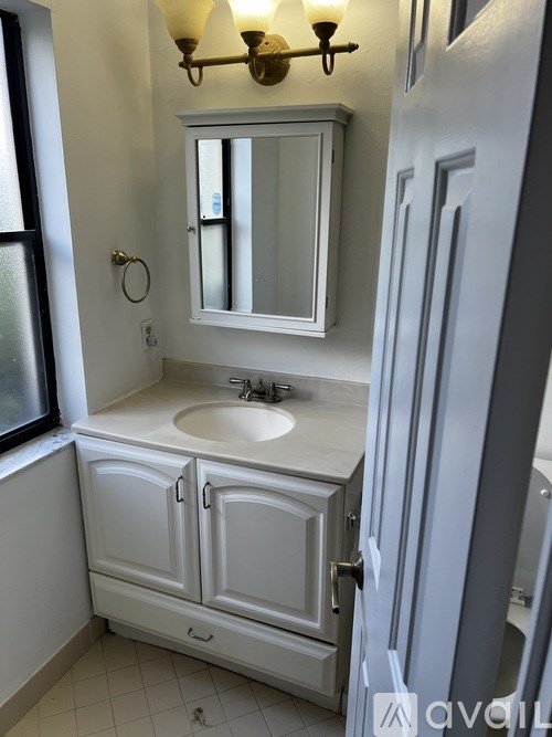 A white bathroom with a sink and mirror.