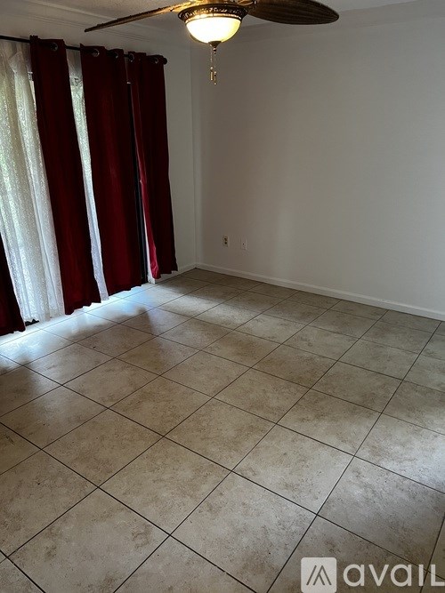 A room with a ceiling fan and tiled flooring.