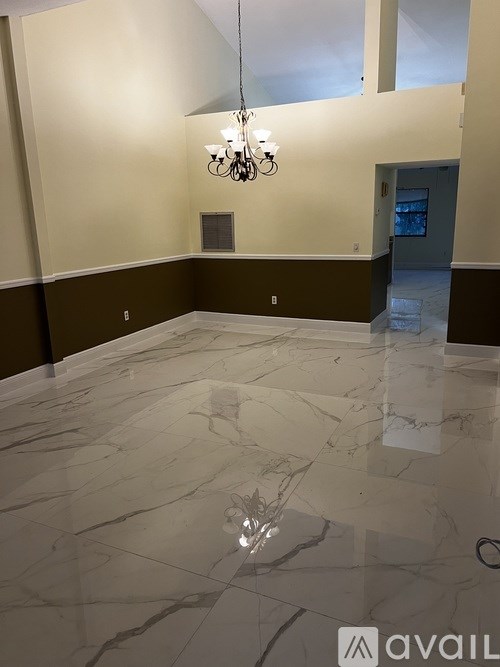 A large room with a marble floor and a chandelier.