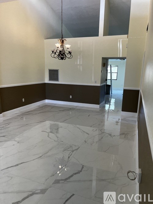 A room with a marble floor and a chandelier.
