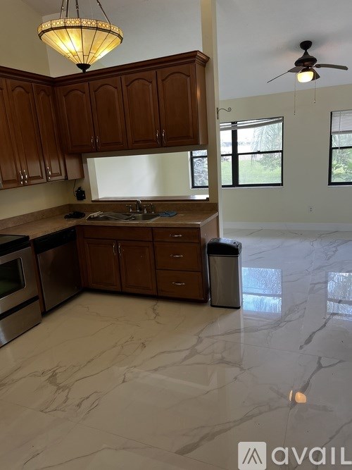 A kitchen with wooden cabinets and a marble floor.