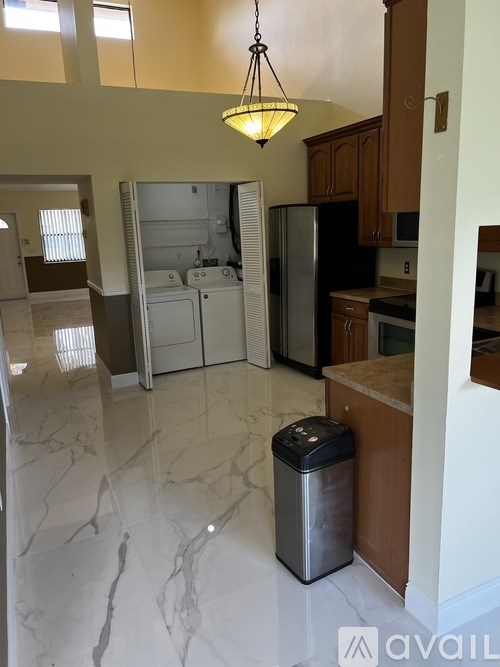A kitchen with a marble floor and a hanging light fixture.