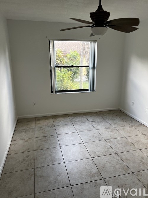 A room with a ceiling fan and a window.