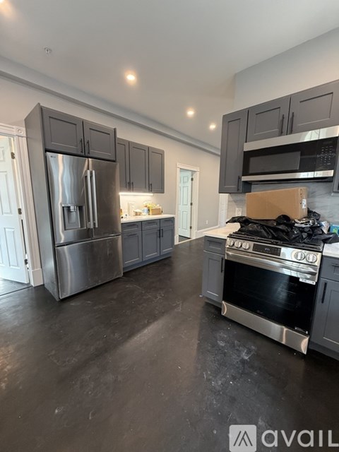A modern kitchen with a stainless steel refrigerator and oven.