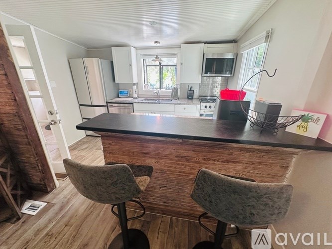A kitchen with a bar counter and two chairs.
