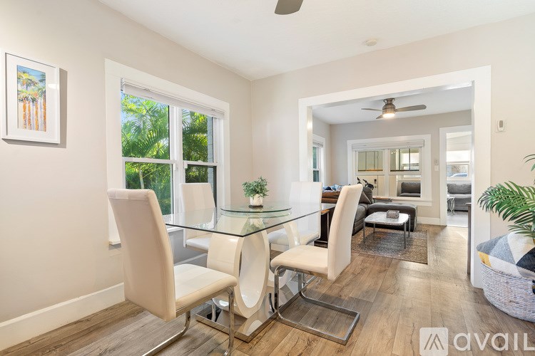 A kitchen with a stainless steel refrigerator and wooden flooring.
