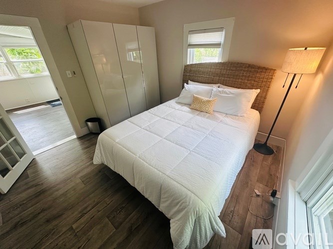 A bedroom with a large bed and a window.