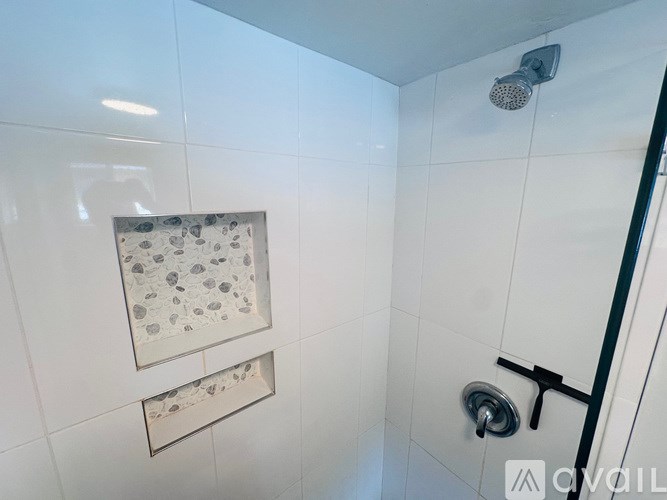 A bathroom with a toilet, a walk-in shower, and a towel hanging on the wall.