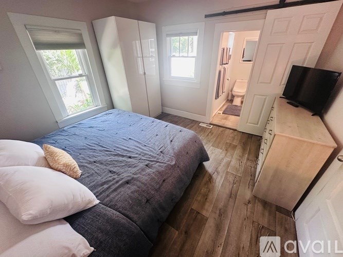 A bedroom with a bed, dresser, and a window.