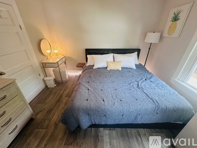 A bedroom with a bed, nightstand, and lamp.