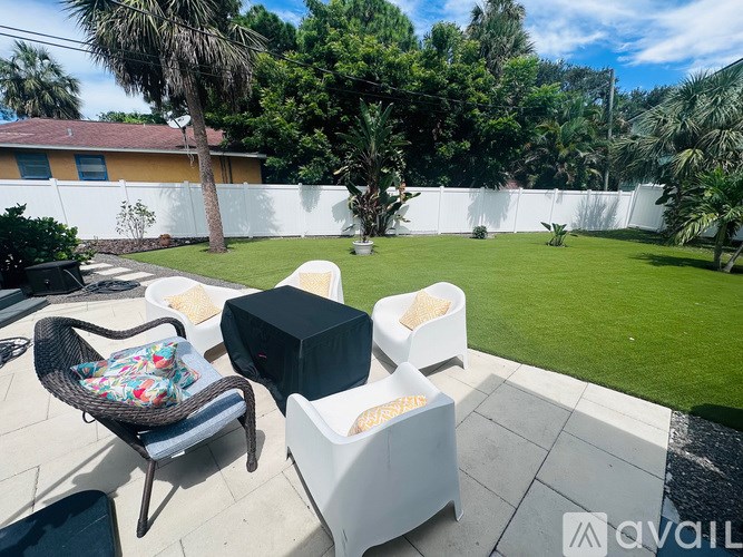 A patio with a chair and a table with a black box on it.