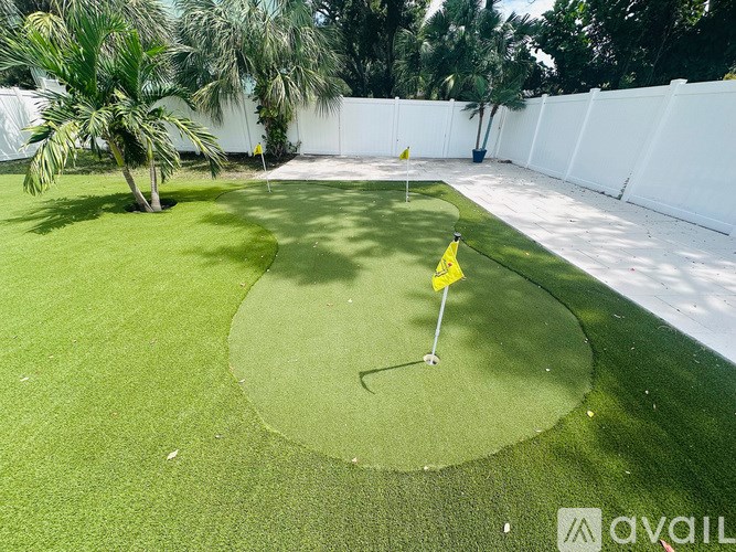 A small putting green with a yellow flag on it.