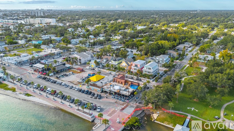 A living room with a television and a bed in the background.