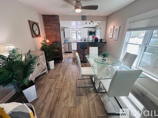 A living room with a glass table and white chairs.