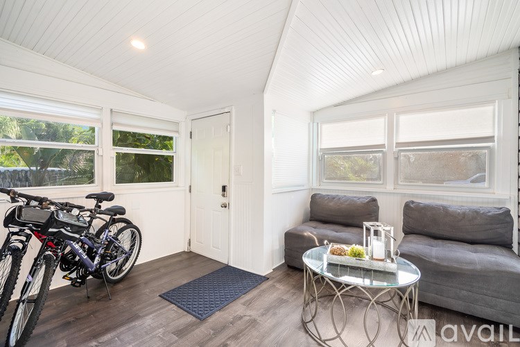 A modern dining room with a glass table and white chairs.
