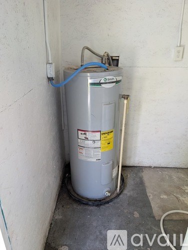 A water heater is installed in a corner of a room.